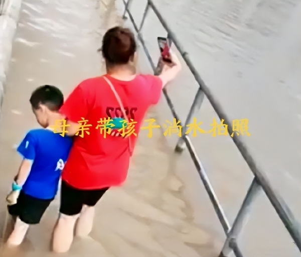 广东暴雨 妈妈带儿子边拍照边蹚水 大家纷纷表示一点也不好玩-1.jpg