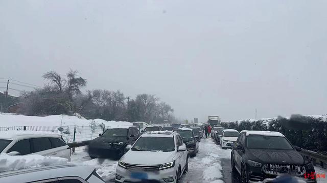 湖北暴雪致约30条高速路关闭，车辆一夜行进不到2公里，村民自发送热水泡面-1.jpg